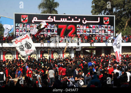 Kairo, Ägypten. 8. März 2013.  Ägyptische Fußball-Fans von Al-Ahly Club feiern vor ihrem Clublokal in Kairo. Eine ägyptische Gericht bestätigte Todesurteile gegen 21 Personen für ihre Rolle in eine tödliche 2012 Fußball-Aufstand, der mehr als 70 Menschen in der Stadt Port Said getötet. Banner im Hintergrund zeigt einige Bilder von den Opfern mit Arabisch, die liest, '' Wir werden dich nie vergessen (Bild Kredit: Kredit: Tareq Gabas/APA Images/ZUMAPRESS.com/Alamy Live News) Stockfoto