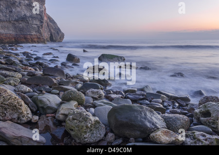 Morgen Flut an einem steinigen Strand vor Sonnenaufgang Stockfoto