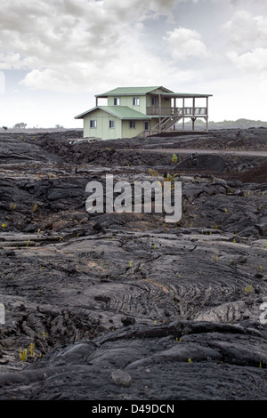 Lava-Formation mit einem Haus im Hintergrund Volcanoes-Nationalpark, Big Island, Hawaii, USA Stockfoto