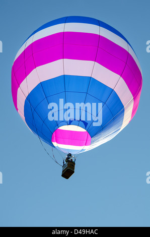 Rosa und blau gestreiften Heißluftballon in einem klaren blauen Himmel. Stockfoto