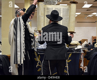 Während der Morgen Gottesdienste am Lubawitsch Sitz hebt ein Verehrer die Thora vor der Heiligen Arche zurückgegeben werden Stockfoto