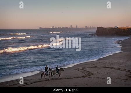 9. März 2013 - Mar Del Plata, Buenos Aires, Argentinien - ein junges Paar Reiten am Strand bei Sonnenuntergang. Pferde und die Landschaft sind fester Bestandteil des argentinischen Lebens und können an vielen Orten wie der Strand und die öffentlichen Parks stundenweise gemietet werden. (Bild Kredit: Ryan Noble/ZUMAPRESS.com ©) Stockfoto