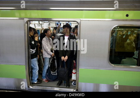 Pendler stehen an Bord der Yamanote-Schleife Zuglinie, die Kreise um die Stadt Tokio, Japan. Stockfoto