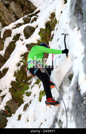 Bergsteiger beginnt des Aufstiegs auf einer großen Wand im winter Stockfoto