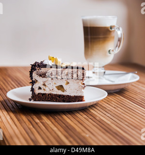 Ein Stück Schokoladenkuchen auf einen Teller, Kaffee im Hintergrund Stockfoto