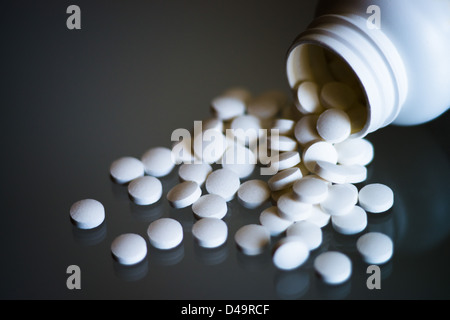 Aspirin-Tabletten fallen aus dem Glas Stockfoto