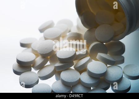 Aspirin-Tabletten fallen aus dem Glas Stockfoto