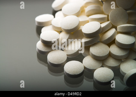 Aspirin-Tabletten fallen aus dem Glas Stockfoto