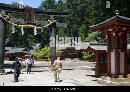 Besucher gehen durch ein Torii-Tor am Futarasan-Schrein in Nikko, Tochigi, Japan. Stockfoto