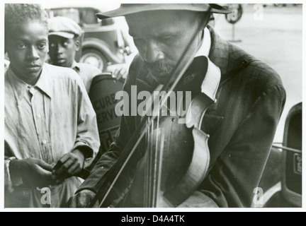 Ein Foto von blinden Straßenmusikern in West Memphis, Arkansas, vom September 1935. Das Bild zeigt zwei afroamerikanische Männer, die Geigen spielen, Teil der Straßenmusiker-Szene aus der Zeit der Großen Depression, aufgenommen von Ben Shahn. Das Foto zeigt die Widerstandsfähigkeit von Musikern in schwierigen Zeiten. Stockfoto