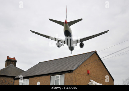 Eine British Airways Flugzeug landet am Flughafen London Heathrow über die Dächer der benachbarten Häuser veranschaulichen Probleme Umgebung Stockfoto