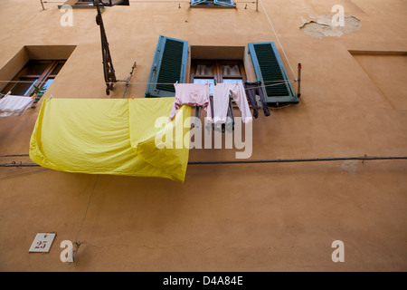 Wäsche hängt an einer Wäscheleine vor einem Fenster in Alghero, Sardinien, Italien Stockfoto