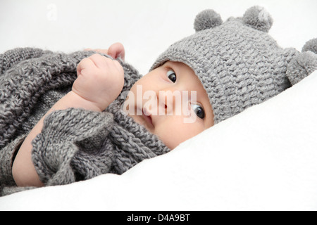 Schöne Baby in graue Strickmütze Stockfoto