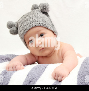 Schöne Baby in graue Strickmütze Stockfoto