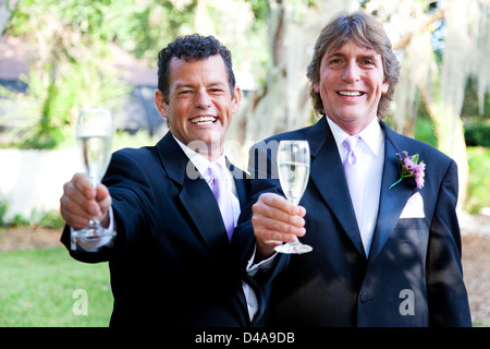 Hübsche Schwule Hochzeitspaar Toasten ihre Ehe mit Champagner. Stockfoto