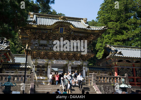 Scharen von Besuchern durch die reich verzierten Yomeimon Tor an der Spitze der Steintreppe im Tōshōgū Jinja Schrein in Nikko, Japan. Stockfoto