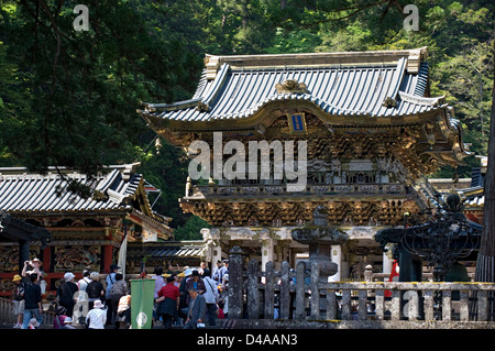 Scharen von Besuchern durch die reich verzierten Yomeimon Tor an der Spitze der Steintreppe im Tōshōgū Jinja Schrein in Nikko, Japan. Stockfoto