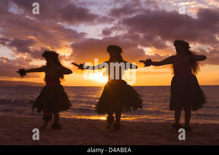 Drei Hula-Tänzer bei Sonnenuntergang am Palauea Beach, Maui, Hawaii. Stockfoto