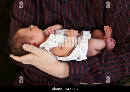Eine Nahaufnahme eines Neugeborenen durch die Hand eines Mannes statt. Stockfoto