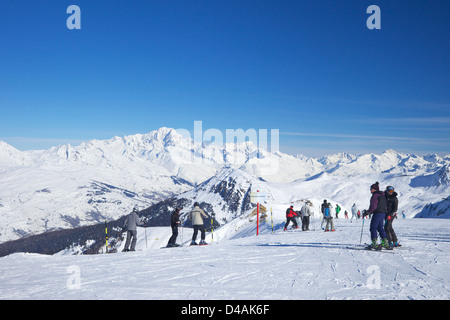 Skifahrer auf Les Verdons blaue Piste im Wintersonne, La Plagne, Frankreich Stockfoto