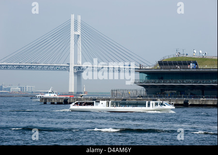 Eine Kreuzfahrt-Schiff Reißverschlüsse an den International Passenger Terminal und Yokohama Bay Bridge an der belebten Uferpromenade von Yokohama, Japan. Stockfoto