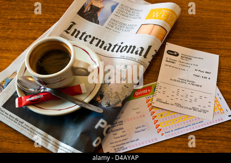 Morgendliche Tasse Kaffee, Wetten rutscht und International Herald Tribune Zeitung - Frankreich. Stockfoto