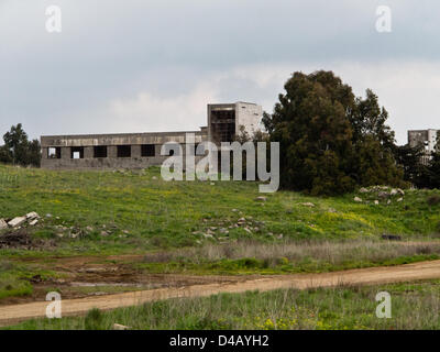 Verlassene Gebäude am Stadtrand von der syrischen Stadt Quneitra jetzt unter israelischer Herrschaft seit Einnahme von den Golan-Höhen in dem Sechstagekrieg von 1967. Golanhöhen, Israel. 10. März 2013.  Blick auf den israelisch-syrischen Grenze auf den Golanhöhen zeigt landwirtschaftliche Felder auf der israelischen Seite im Vordergrund, der UNDOF-zentrale und der syrischen Stadt Quneitra jenseits der Waffenstillstandslinie von 1974. Stockfoto