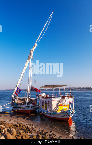 Felucca und Unterstützung Touristenboot vertäut am Ufer des Nils in der Nähe von Assuan bei Sonnenaufgang. Stockfoto