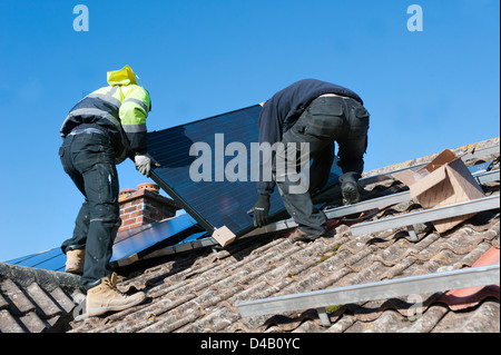 Arbeiter, die Installation von solar-pv-Panels auf Hausdach Stockfoto