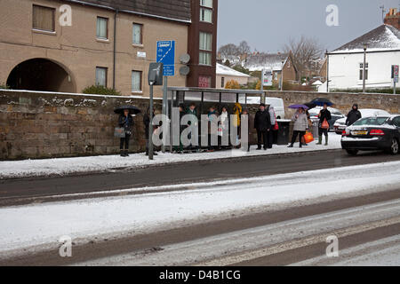 Edinburgh, Schottland. 11. März 2013. Willowbrae Bereich im schottischen Edinburgh leidet seine erste Störung der Schnee des Winters, eine Mutter bekommt ihre Kinder zur Schule mit Schlitten und der Hauptverkehrszeit-Bus-Warteschlangen zu verlängern, da der Datenverkehr sichert Stockfoto