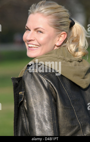 Blonde Frau auf der Suche über die Schulter außerhalb Stockfoto