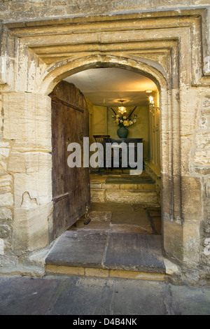 Eine alte Tür öffnet sich auf eine antike eingerichtete Eingangshalle Interieur. Stockfoto