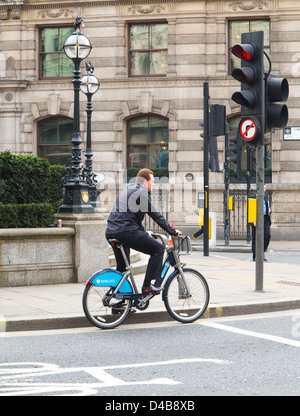 Mann mit dem "Boris Bike", ein blauer Barclays gesponserten Fahrrad Verleih Schema in London, England Stockfoto