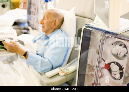 Nieren-Patienten auf regelmäßigen Besuch Dialyse Station London Hospital, wo er im wesentlichen Hämodialysegerät verbunden, reinigt Stockfoto