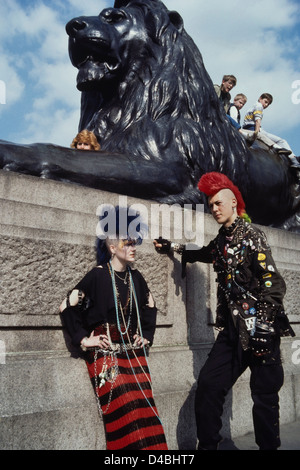 Ein paar Punk Rocker mit farbigen mohican Haar erregen die Aufmerksamkeit der Touristen am Trafalgar Square, London. Ca. 80er Stockfoto