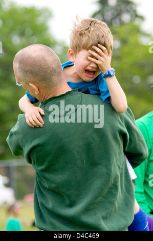 Weinende junge Fußballspieler dahingerafft Feld von Vater nach ein Fußball-Verletzungen Sport. St Paul Minnesota MN USA Stockfoto