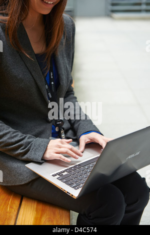 Eine Geschäftsfrau auf der neuen ASUS Zenbook, ein ultraflaches Notebook mit einem metallic-Finish, Stereo-Lautsprecher und beleuchtete Tasten. Stockfoto