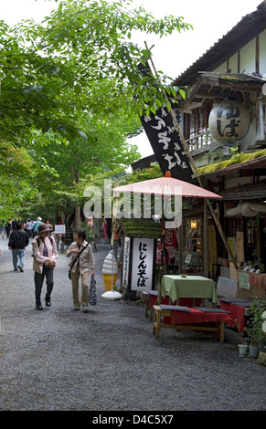 Besucher genießen einen Spaziergang entlang eines Weges vorbei an Geschäften und Restaurants im ländlichen Berg Dorf von Ohara, Kyoto, Japan Stockfoto