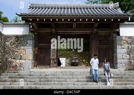 Besucher verlassen durch den Haupteintrag Sanmon Tor der Tendai-Sekte Sanzenin Tempel in ländlichen Dorf von Ohara, Kyoto, Japan. Stockfoto