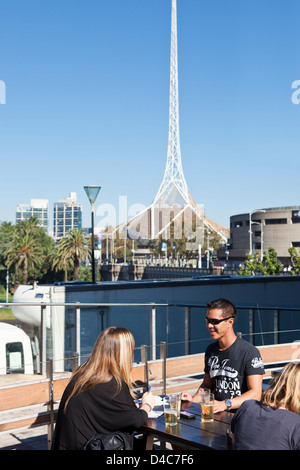 Menschen entspannen in bar am Federation Square mit Turm der Victorian Arts Centre im Hintergrund. Melbourne, Victoria, Australien Stockfoto