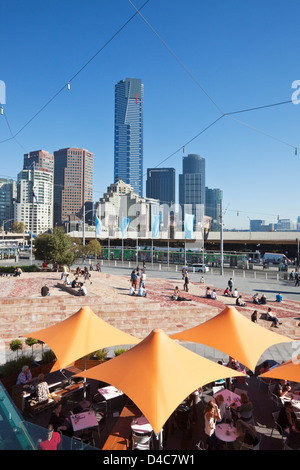 Cafe und Platz am Federation Square mit Skyline der Stadt im Hintergrund.  Melbourne, Victoria, Australien Stockfoto