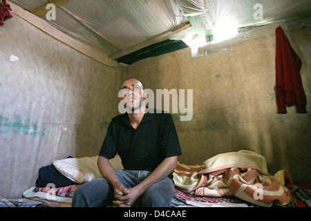 25-j hrige El Mostafa aus Marokko sitzt auf seinem Bett in seiner Hütte aus Paletten aus Holz, Pappe und Kunststoff Verkleidungen in El Ejido, Spanien, 9. Oktober 2007. El Mostafa ist einer der vielen Tagelöhner, die außerhalb der Stadt in eine so genannte "Chabola", fehlende sanitäre Einrichtungen, fließendes Wasser und rechtliche Strom lebt und arbeitet in den regionalen Gewächshäusern. Foto: Bodo Marks Stockfoto