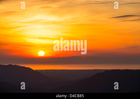 Die untergehende Sonne über der Isle Of Man, gesehen vom Hardknott-Pass, blickte Eskdale im Lake District, UK. Stockfoto