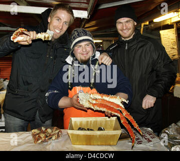 Deutsche national Team Handballer Oliver Roggisch (L) und Torhüter Henning Fritz (R) posieren mit Fischhändler Daniel Alban (C) und eine große Schrimp in der Altstadt von Bergen, Norwegen, 18. Januar 2008. Foto: Jens Wolf Stockfoto