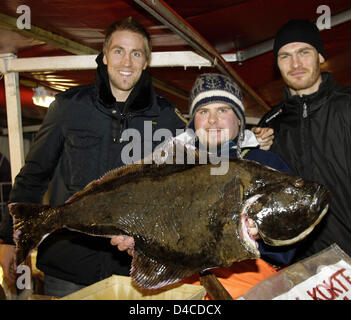 Deutsche national Team Handballer Oliver Roggisch (L) und Torhüter Henning Fritz (R) posieren mit Fischhändler Daniel Alban (C), wer ein großer Heilbutt in seinen Händen in die Altstadt von Bergen, Norwegen, 18. Januar 2008 hält. Foto: Jens Wolf Stockfoto