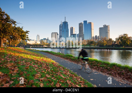 Radfahrer am Ufer des Yarra River mit Skyline der Stadt im Hintergrund. Melbourne, Victoria, Australien Stockfoto