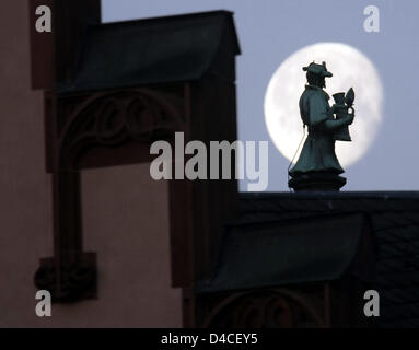 Eine historische Statue mit einem Bierkrug ist vor dem Mond auf dem Dach des historischen Rathauses "Römer" in Frankfurt Main, Deutschland, 25. Januar 2008 abgebildet. Sonnenschein ist für Hessen vorhergesagt. Foto: Frank Rumpenhorst Stockfoto