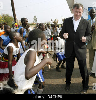 Deutschlands President Horst Koehler (C) tanzt zu den Klängen der traditionellen Musik und Tanz-Gruppe am Flughafen in Gulu, Uganda, 5. Februar 2008. Herr Koehler und seine Frau Eva Koehler sind auf einem dreitägigen Besuch in Uganda und wird dann weiter nach Ruanda. Foto: WOLFGANG KUMM Stockfoto