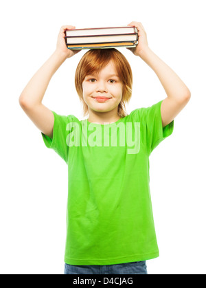 Glücklich kaukasischen 9 Jahre alter Junge im grünen Hemd Holding Stapel Bücher auf Kopf Porträt, isoliert auf weiss Stockfoto