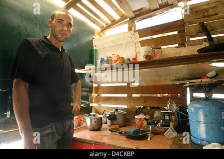 25-j hrige El Mostafa aus Marokko steht im Kochbereich von seiner Hütte aus Paletten aus Holz, Pappe und Kunststoff Verkleidungen in El Ejido, Spanien, 9. Oktober 2007. El Mostafa ist einer der vielen Tagelöhner, die außerhalb der Stadt in eine so genannte "Chabola", fehlende sanitäre Einrichtungen, fließendes Wasser und rechtliche Strom lebt und arbeitet in den regionalen Gewächshäusern. Foto: Bodo Marks Stockfoto